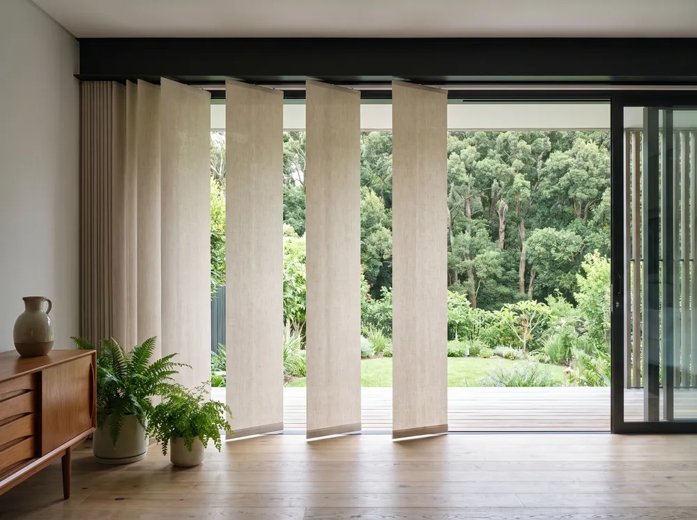 Flat panel-glide blinds sliding across a wide glass door onto a Newlands garden terrace